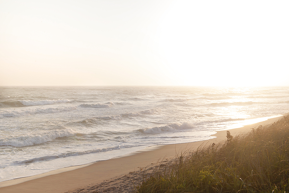 Sun setting over calm ocean and Cisco Beach