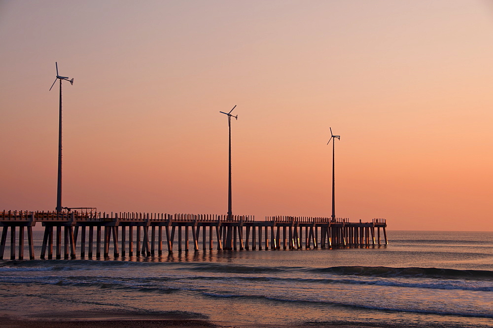 USA, North Carolina, Outer Banks, Kill Devil Hills, pier with wind turbines at sunset