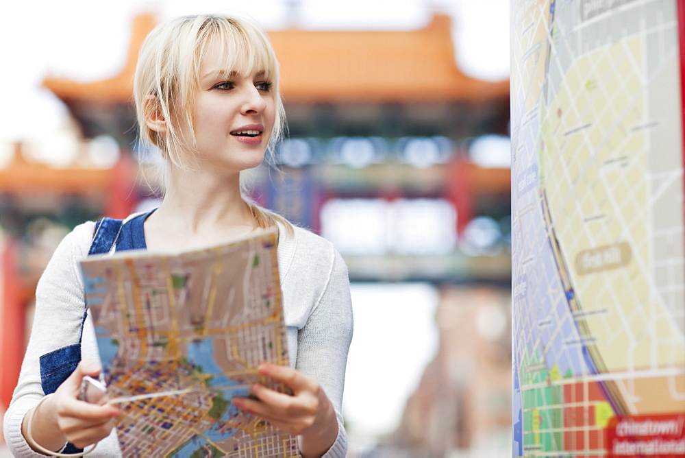 USA, Seattle, Smiling young woman holding map