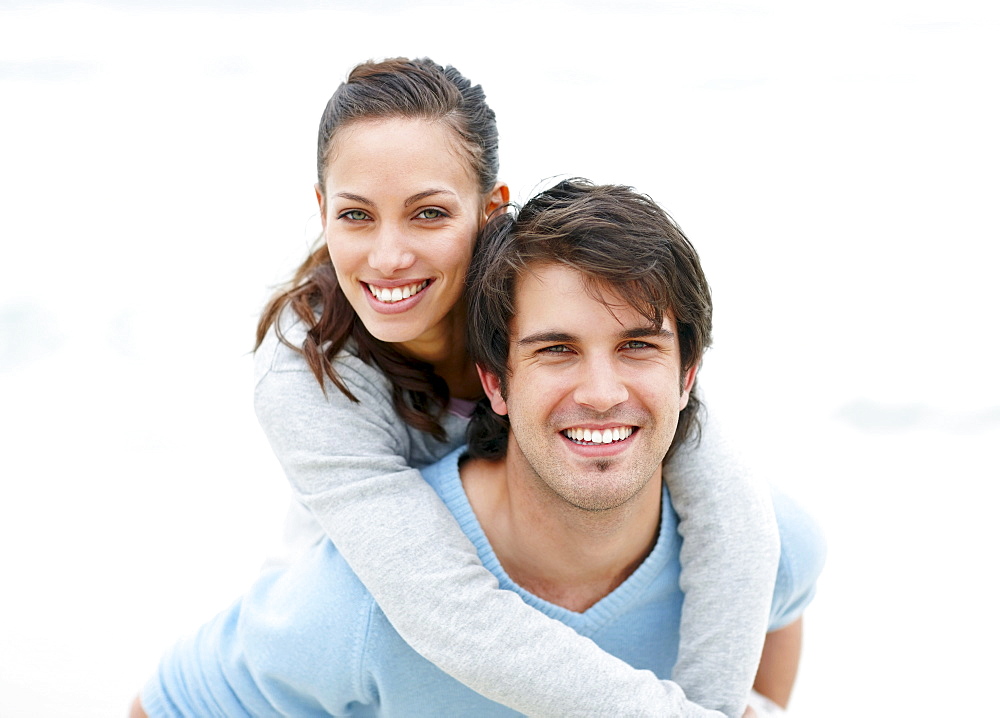 Man giving woman a piggy back ride