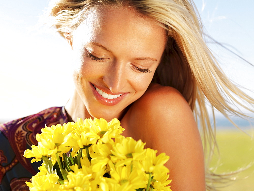 Blond woman holding yellow flowers