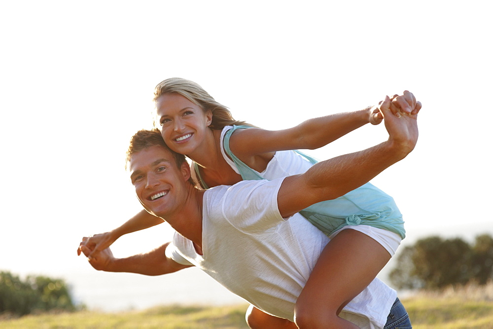 Man giving girlfriend a piggy back ride