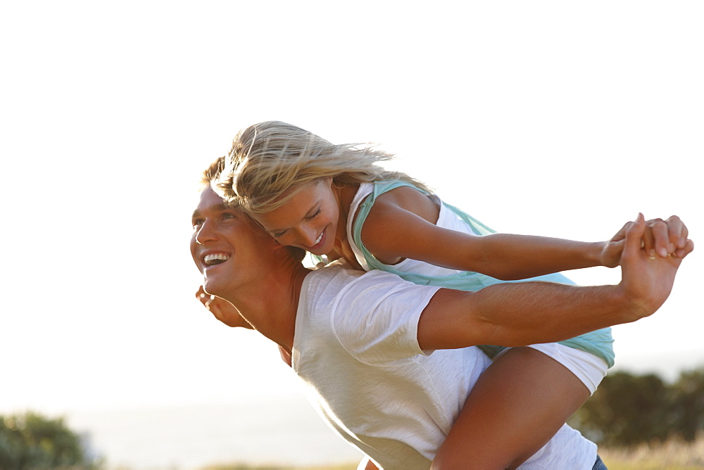 Man giving girlfriend a piggy back ride