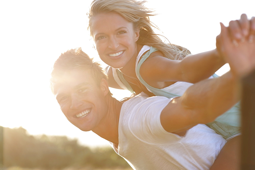 Man giving girlfriend a piggy back ride