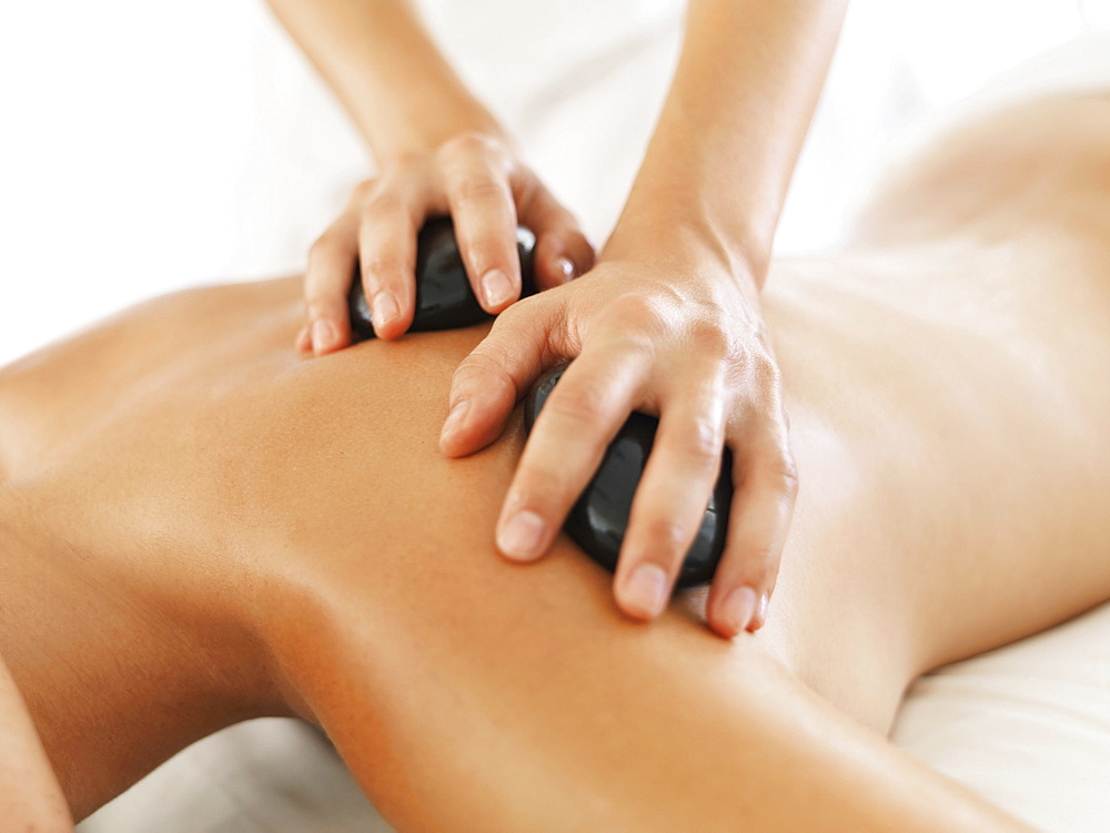 Woman relaxing while getting stone massage