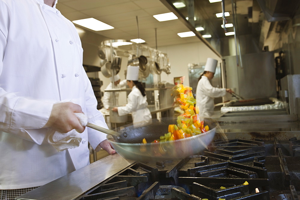 Chef tossing food in skillet