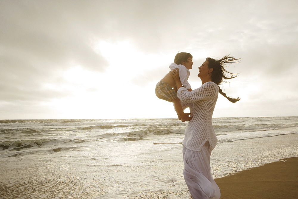 Mother holding son at beach