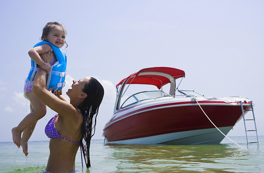 Mother holding up daughter in water, Florida, United States