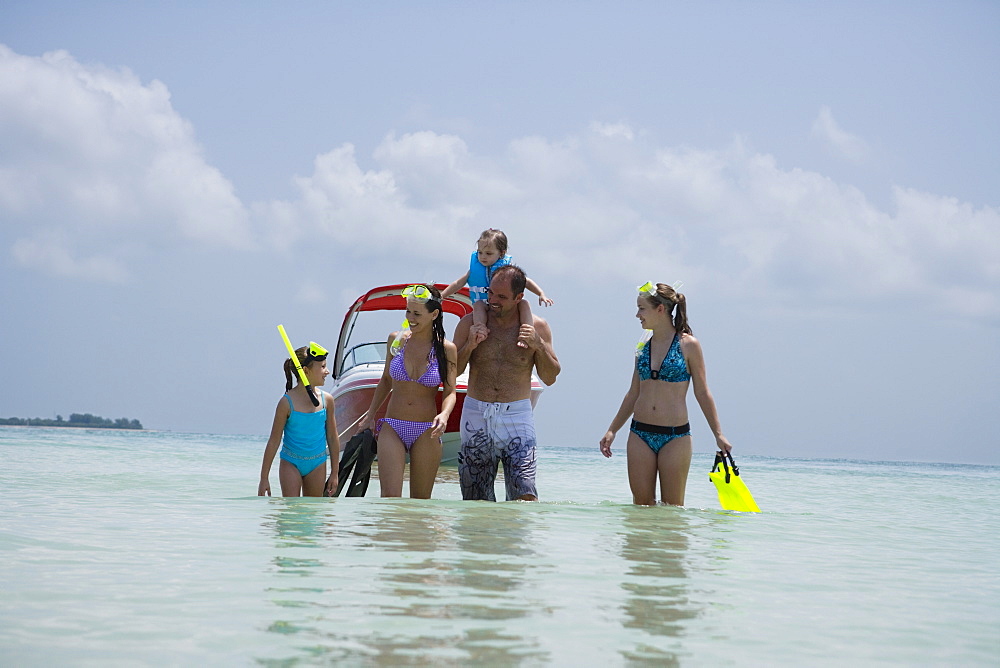 Family with snorkeling gear walking in water, Florida, United States