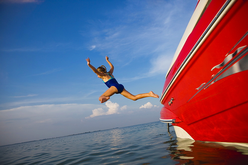 Young girl jumping off boat, Florida, United States