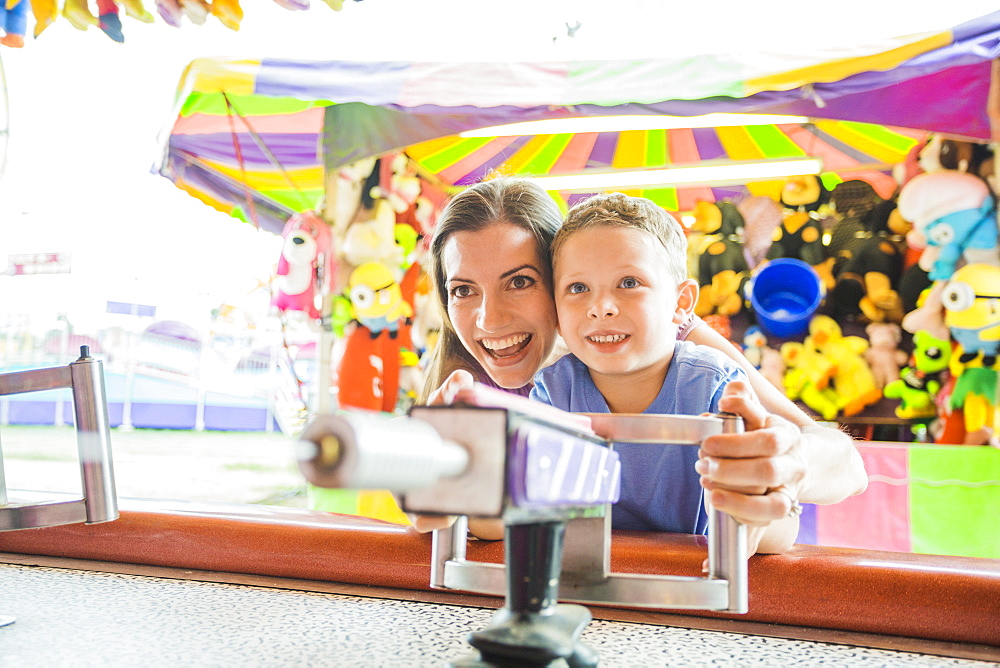 Mother and son (4-5) playing with water gun in amusement park, USA, Utah, Salt Lake City 