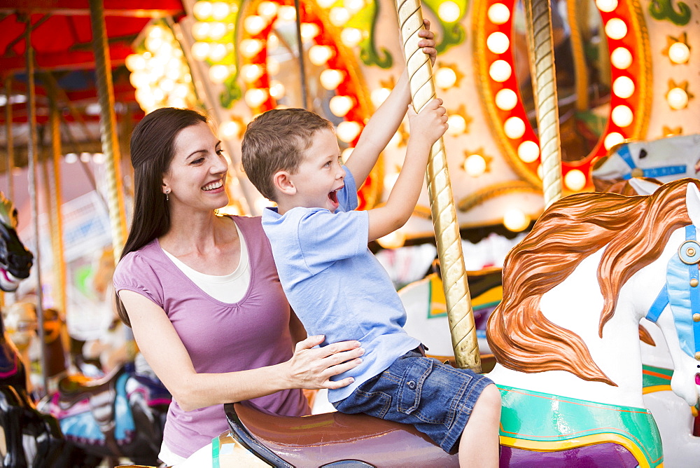 Mother and son (4-5) on carousel in amusement park, USA, Utah, Salt Lake City 