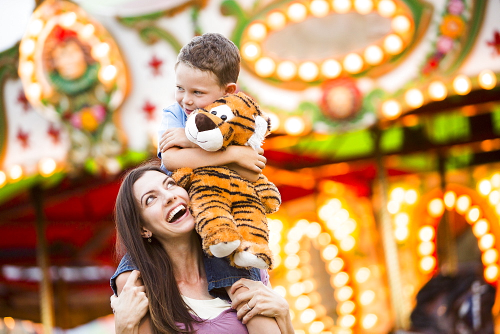 Mother giving her son (4-5) piggyback ride in amusement park, USA, Utah, Salt Lake City 