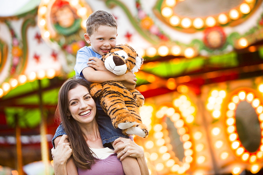 Mother giving her son (4-5) piggyback ride in amusement park, USA, Utah, Salt Lake City 