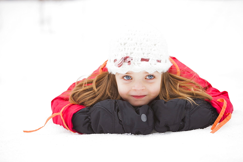 Portrait of girl (2-3) lying on snow