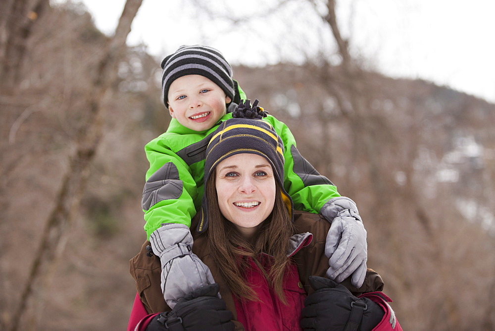 Portrait of young woman carrying boy (4-5) on shoulders 