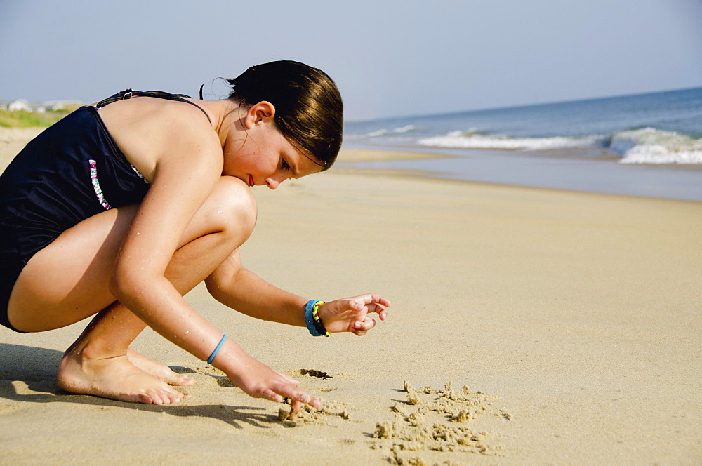 Girl (8-9) playing at beach, Nags Head, North Carolina