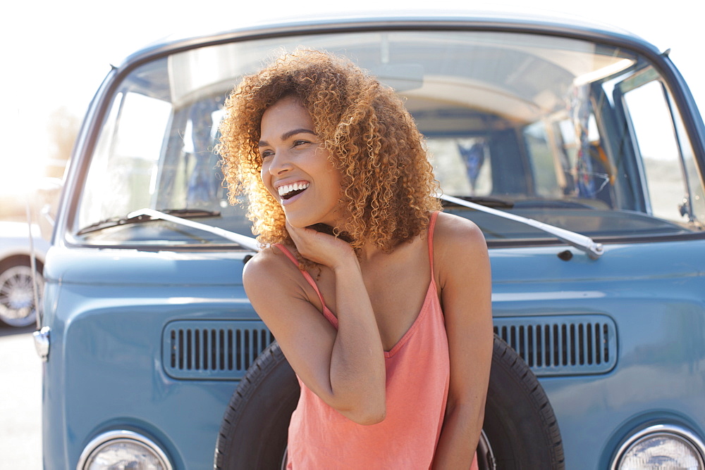 Smiling woman standing in front of van