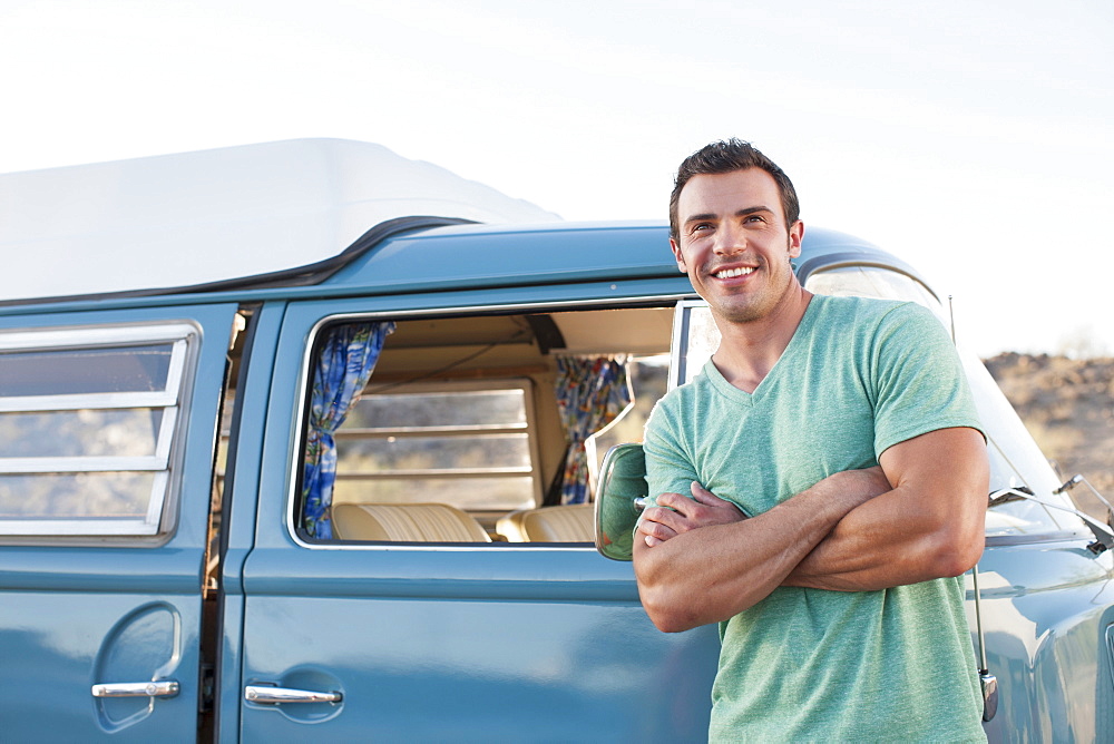 Man in front of his mini van during road trip
