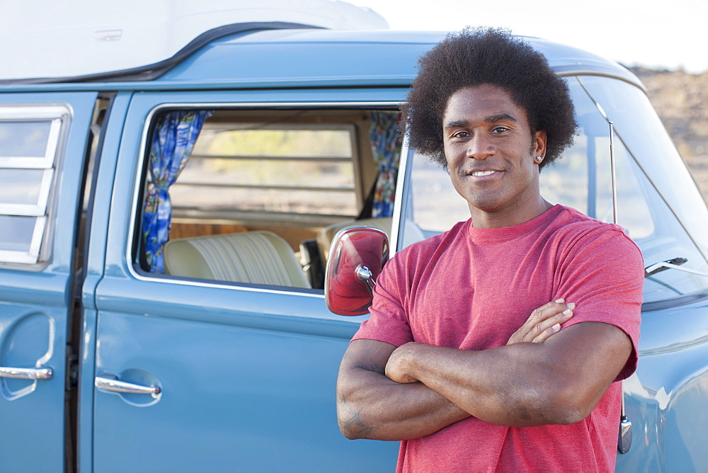 Man in front of his mini van during road trip