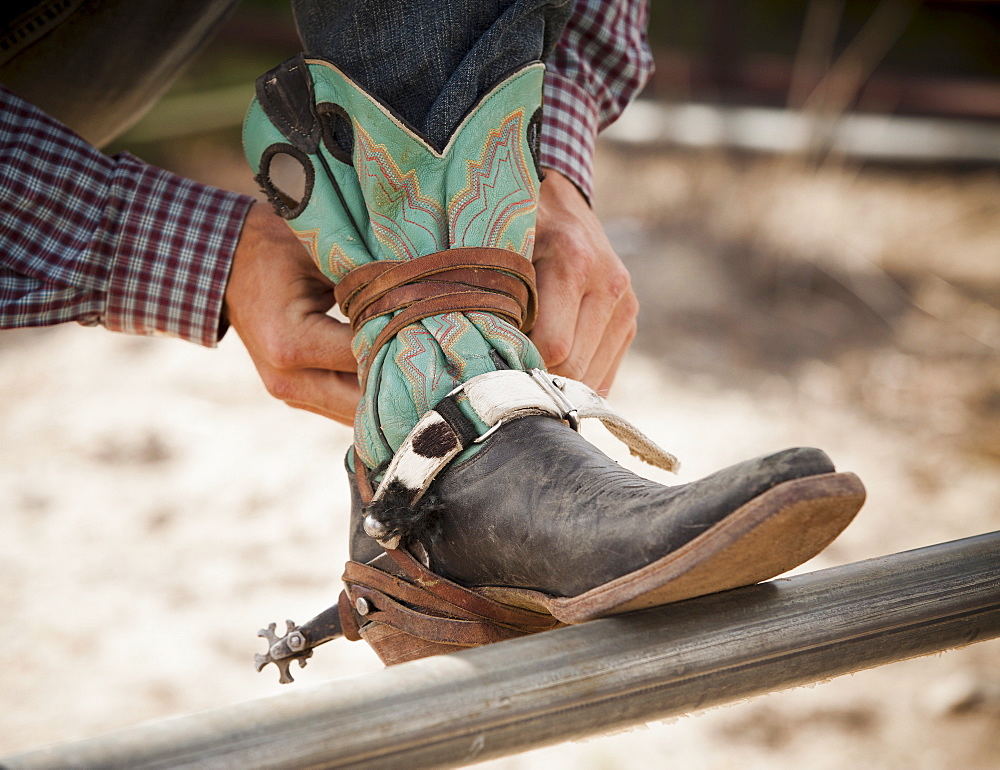 Close-up of cowboy tying shoe