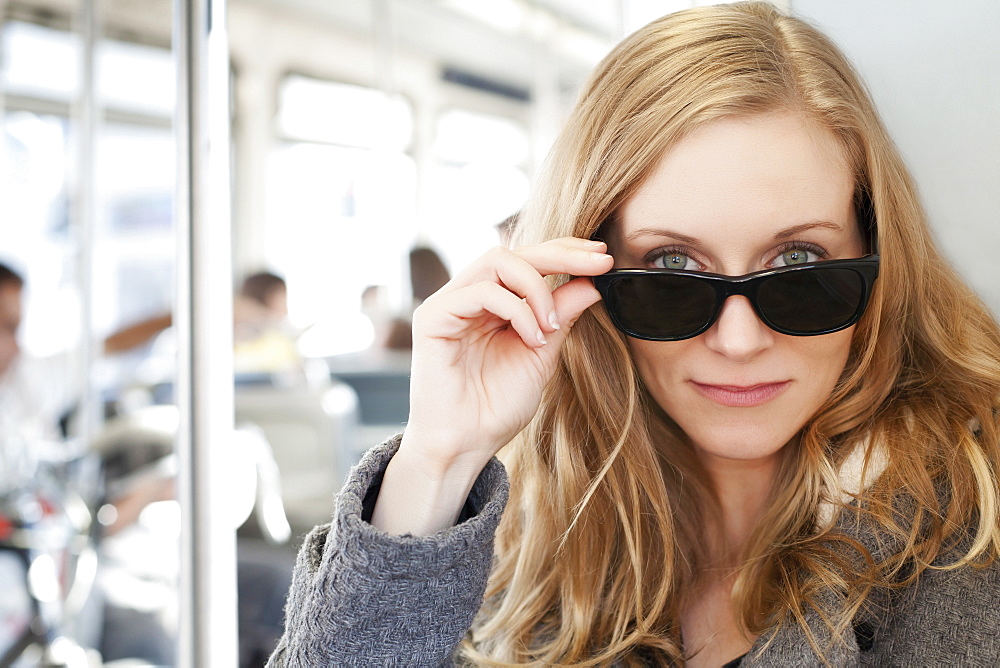 Portrait of woman wearing sunglasses in subway train