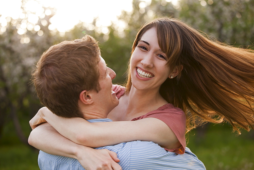 Young couple embracing in orchard