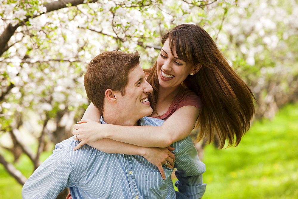 USA, Utah, Provo, Young couple embracing in orchard