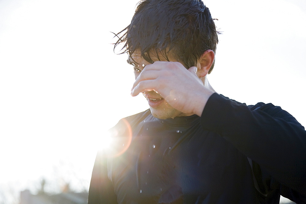 Man in sports clothing back lit by sun