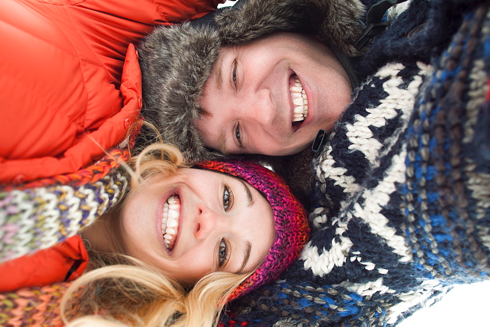 Portrait of young couple lying in snow