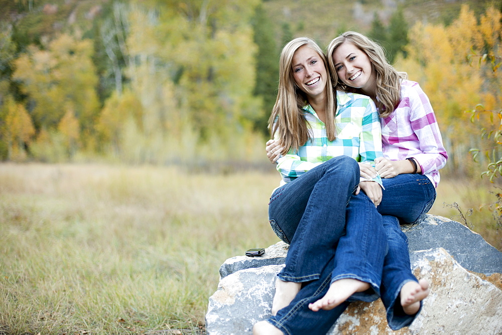 USA, Utah, Sundance, Portrait of two young women sitting on boulder