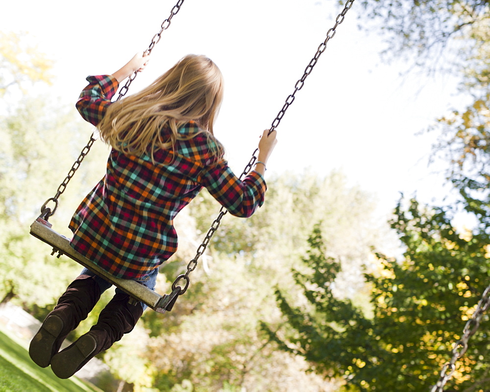 USA, Utah, girl  (6-7) swinging on tree swing