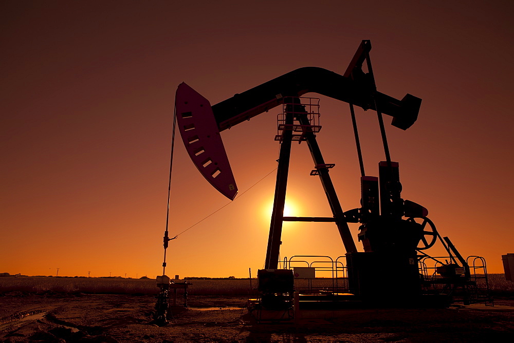 Silhouette of oil pump jack on rig