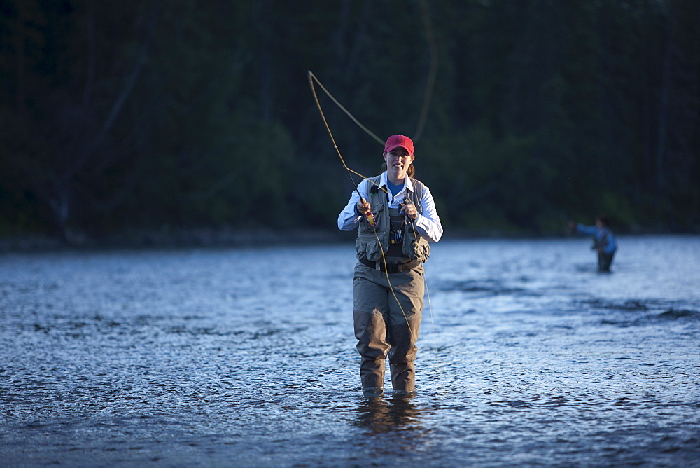 Canada, British Columbia, Fernie, Portrait of woman fly fishing in river