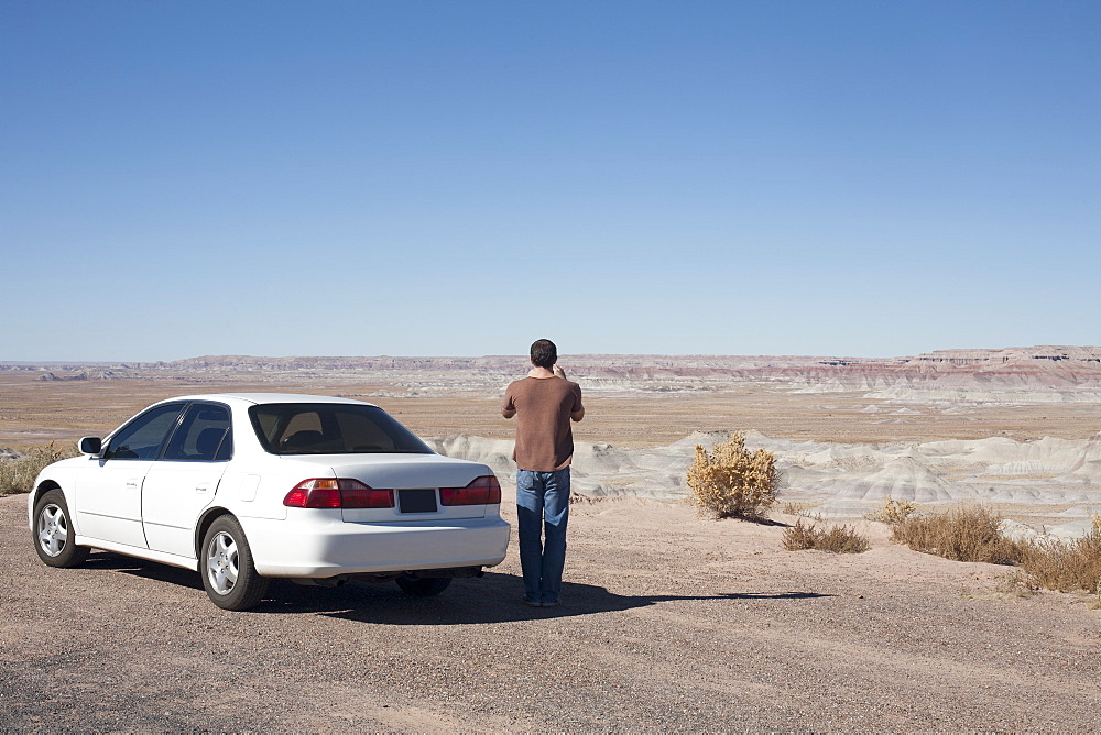 USA, Arizona, Painted Desert. Little Painted Desert, Man standing near car and looking at view