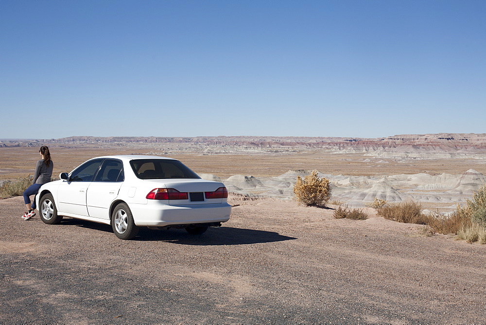 USA, Arizona, Painted Desert. Little Painted Desert, Woman leaning on car and looking at view