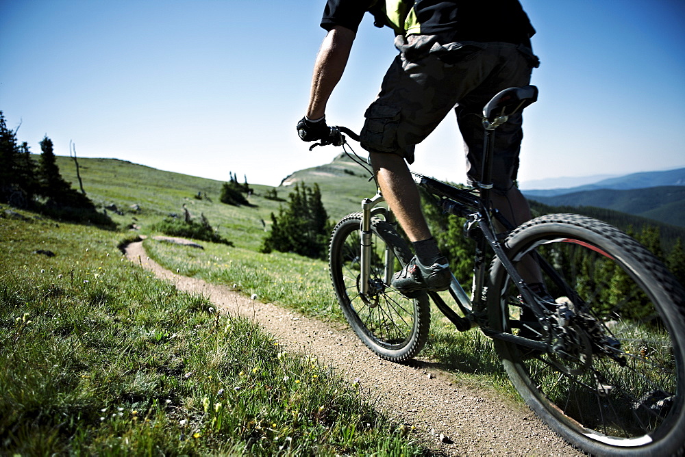 Man mountain biking on mountain track