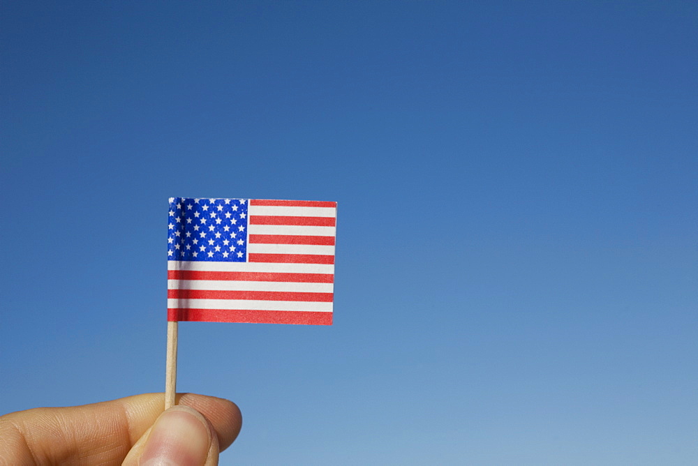 Hand holding small American flag