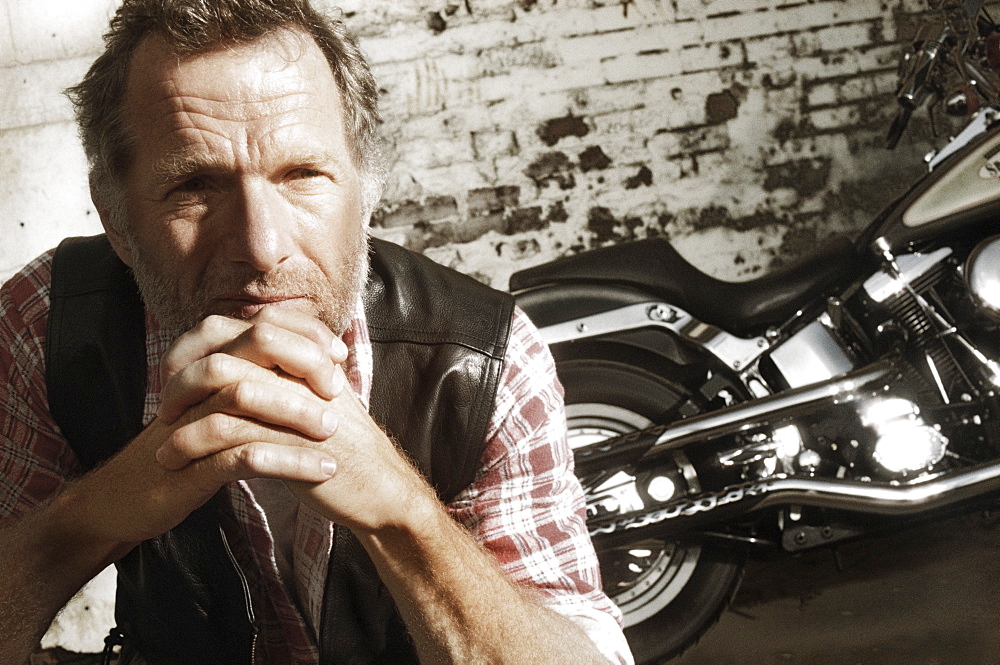 Mature man in front of motorcycle