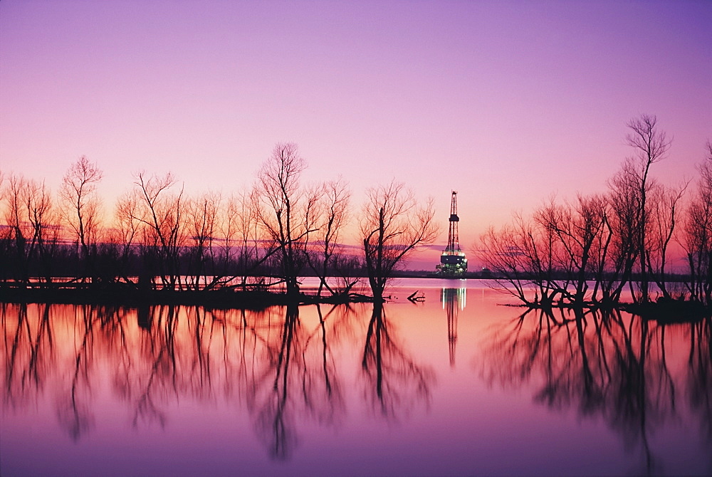 Oil platform in distance at sunset, Louisiana