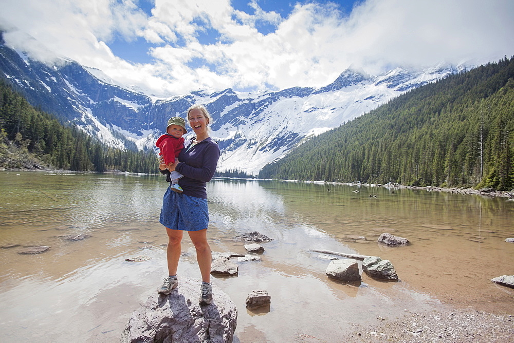 Woman with son (4-5) standing on lakeshore, Avalanche Lake, Glacier National Park, Montana, USA