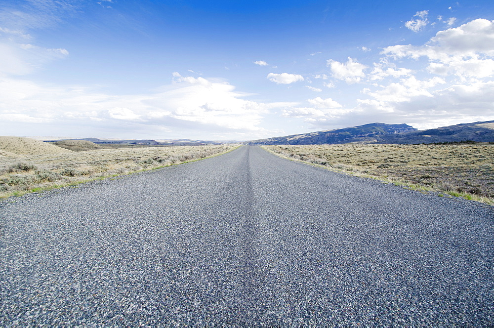 Road going through desolate landscape, Wyoming, USA