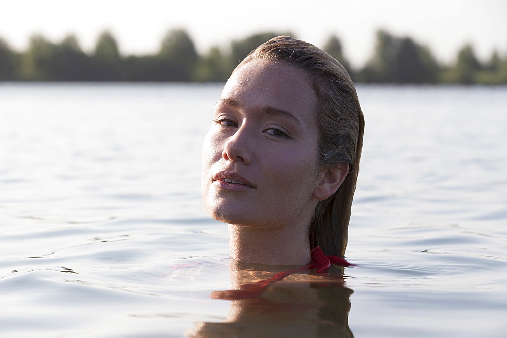 Woman relaxing in lake, Looking at camera, Netherlands, Gelderland, De Rijkerswoerdse Plassen