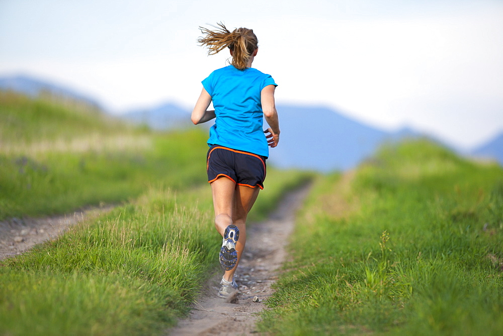 Rear view of young woman jogging, Kalispell, Montana, USA