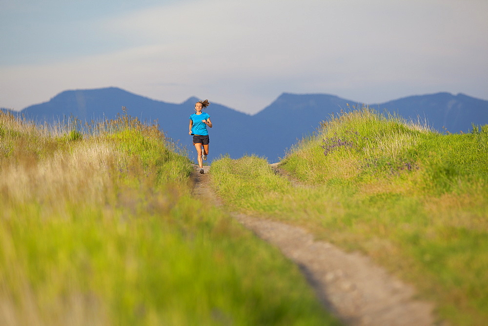 Distant view of young woman jogging, Kalispell, Montana, USA