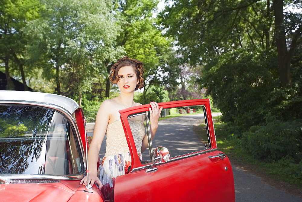 Portrait of elegant woman next to vintage car, Goirle