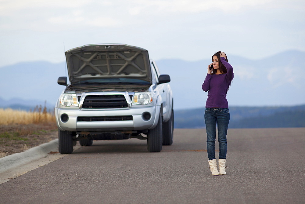 Woman calling for assistance after vehicle breakdown, Whitefish, Montana, USA