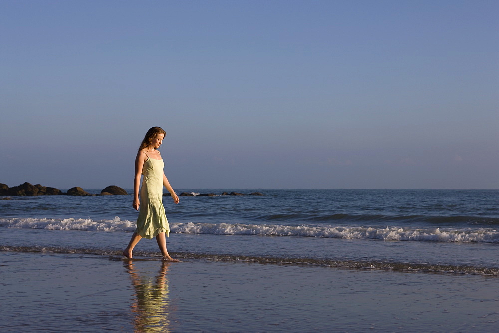 France, Pas-de-Calais, Escalles, Young woman strolling on empty beach, France, Pas-de-Calais, Escalles