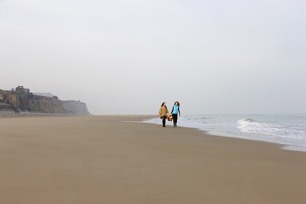 France, Pas-de-Calais, Escalles, Two women strolling on empty beach, France, Pas-de-Calais, Escalles