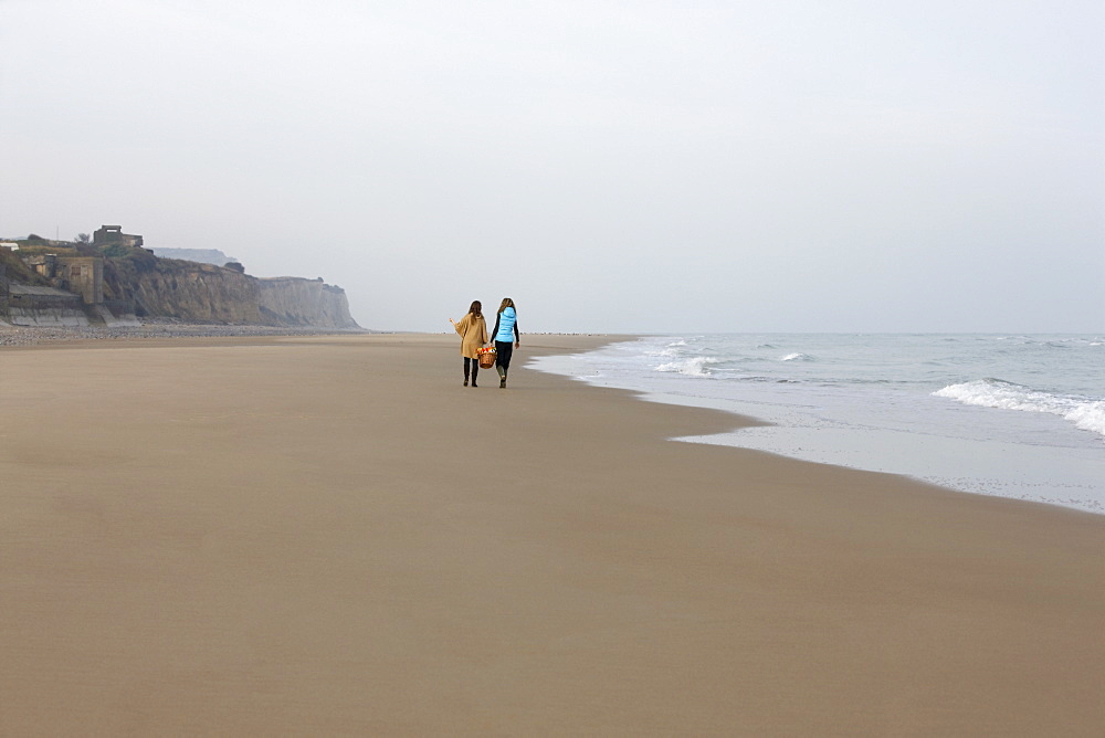 France, Pas-de-Calais, Escalles, Two women strolling on empty beach, France, Pas-de-Calais, Escalles